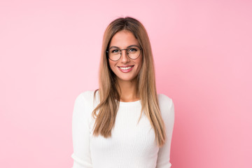 Young blonde woman over isolated pink background with glasses - obrazy, fototapety, plakaty