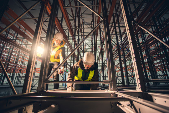 Two Technician Repairing Machine Shelf In Dark Room Warehouse.