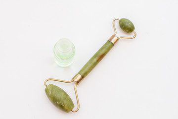 face massager and perfume top view on white