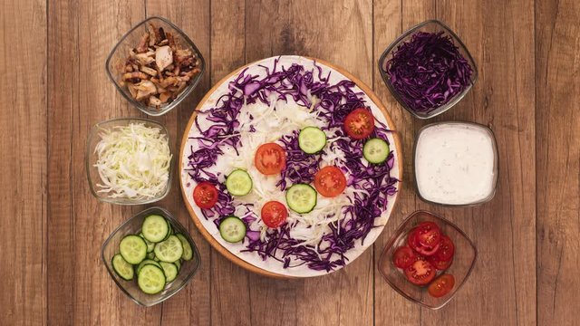 Making a kebab or gyros - a traditional roll sandwich wrapped in wheat flour wraps and various fresh ingredients - with a side of fried potato, top view, flat lay