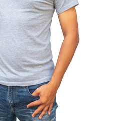 A man in a gray T shirt and denims holds his hands in pockets on whitebackground.
