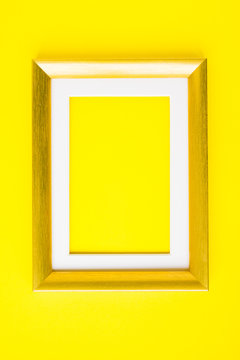 Empty picture frame gold wood frame on yellow