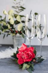 Composition with glass for champagne. Flowers and hearts on grey concrete background.
