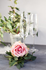 Composition with glass for champagne. Flowers and hearts on grey concrete background.