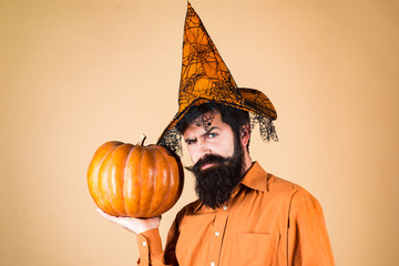 Thanksgiving seasonal cooking ingredients. Scary hipster man with beard in Halloween hat. Trick or...