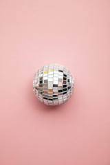 Disco glitter mirror ball on a pastel pink background