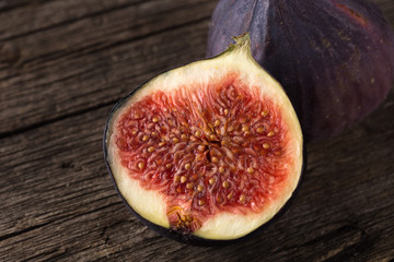 Fresh ripe figs. A few figs on an old wooden background. Whole figs and one fig sliced. Fresh...