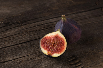 Fresh ripe figs. A few figs on an old wooden background. Whole figs and one fig sliced. Fresh...