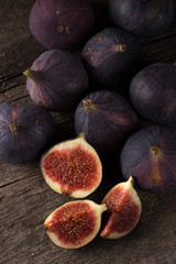 Fresh ripe figs. A few figs on an old wooden background. Whole figs and one fig sliced. Fresh...