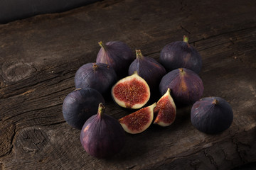 Fresh ripe figs. A few figs on an old wooden background. Whole figs and one fig sliced. Fresh...
