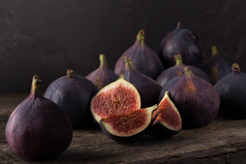 Fresh ripe figs. A few figs on an old wooden background. Whole figs and one fig sliced. Fresh...