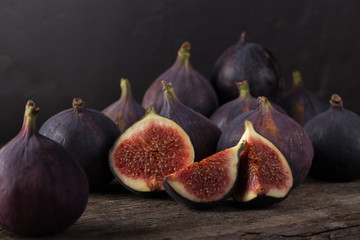 Fresh ripe figs. A few figs on an old wooden background. Whole figs and one fig sliced. Fresh...