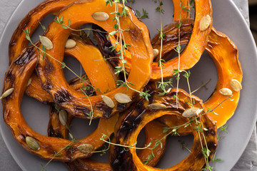Pumpkin grill served on a plate. Baked pumpkin sliced rings with a knife, fork and napkin on a...