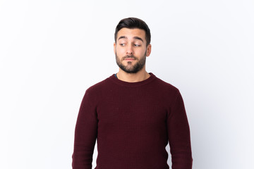 Fototapeta premium Young handsome man with beard over isolated white background making doubts gesture looking side