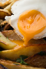 Breakfast in the pan. Fried potatoes with eggs in a skillet. Food bachelor. Cooked by a man. Hot and fresh. Homemade breakfast on black table. Fried eggs and sweet potato hash in cast iron skillet Fre