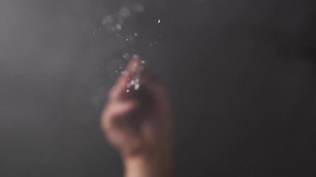 The male hand is heavily salting something. Cook with spices