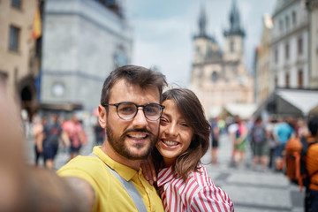 Couple in a vacation trip in city streets at Prague  on vacation making selfie..