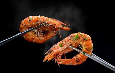 Grilled shrimps prawn with chopsticks.