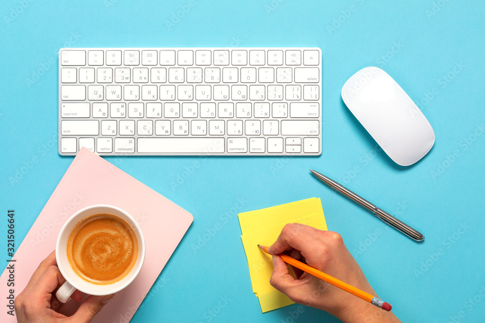 Poster top view of business working place with cup of coffee. empty workspace on blue table background
