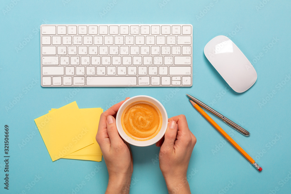 Poster top view of business working place with cup of coffee. empty workspace on blue table background