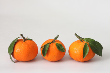 Three ripe tangerines on a white background