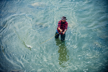 Weekend fishing. Happy fisherman in water. Bearded elegant man. Make with inspiration. Lifestyle concept. Man fishing. Just do that only. Handsome man relaxing with fish. Male fly fish hobby.