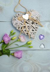 Valentine's day background with hearts and spring flowers on a blue wooden background, vertical composition.