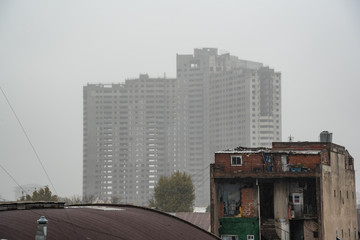 Avellaneda, Buenos Aires, Argentina; June 13, 2019: View of an abandoned building under construction (white elephant) covered in fog on top. In front you can see an urban image surrounding