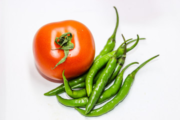 A picture of green chilies with fresh tomato