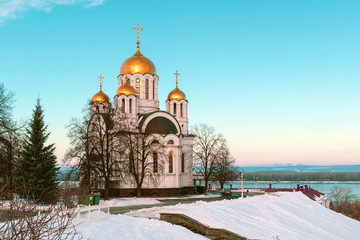 Obraz premium The Russian Church over the river on the background of blue sky