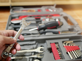 Fototapeta premium A man's hand is holding a wrench in various sizes in a toolbox.