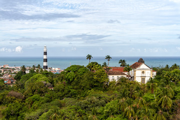 View of Olinda Lighthouse and Church of Our Lady of Grace, Catholic Church built in 1551, surounded by palm trees, Olinda, Pernambuco, Brazil