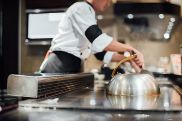 Hand of man take cooking of meat with vegetable grill, Chef cooking wagyu beef in Japanese teppanyaki restaurant