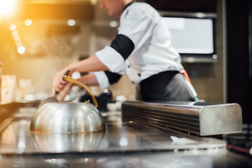 Hand of man take cooking of meat with vegetable grill, Chef cooking wagyu beef in Japanese teppanyaki restaurant