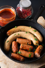 Food concept organic homemade meat sausage and smoked sausage in skillet iron pan with copy space