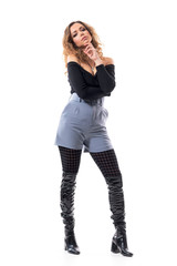 Confident attitude slim fashion model with curly hair woman posing with finger on chin. Full body...