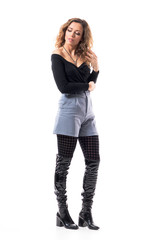 Sad pensive young beautiful woman in stylish outfit looking down and thinking with hand in hair. Full body length isolated on white background.