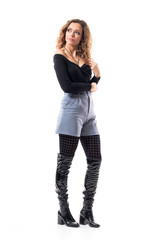 Stylish beautiful curly hair girl touching hair looking up over shoulder with hope and aspiration. Full body length isolated on white background.