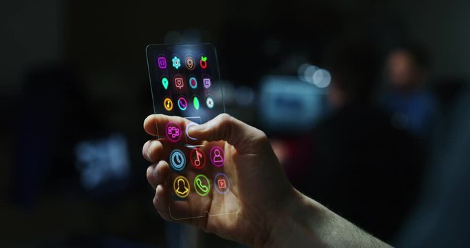 Close up of a man hand is watching videos by using a futuristic liquid crystals cell phone with the latest advanced augmented reality holographic technology. Concept: future, technology,holograms