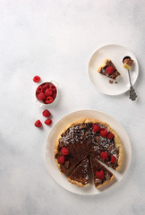 Chocolate cake with cottage cheese and raspberries on a light background. Background image, copy space
