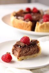 Chocolate cake with cottage cheese and raspberries on a light background. Background image, copy space