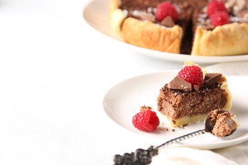 Chocolate cake with cottage cheese and raspberries on a light background. Background image, copy space