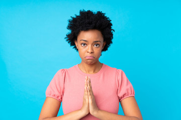 African american woman over isolated blue background pleading