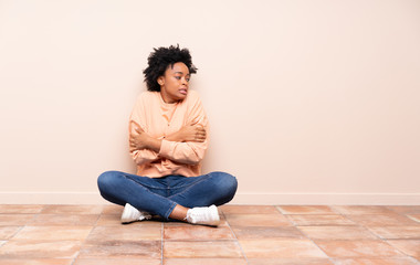 African american woman sitting on the floor freezing