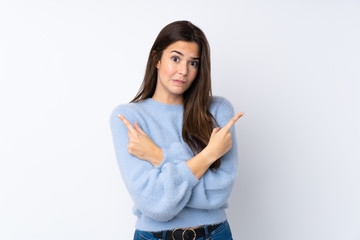 Teenager girl over isolated white background pointing to the laterals having doubts