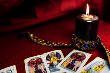 black candle with esoteric letters on red cloth, esoteric concept