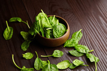 Spinach fresh green leaves in a wooden bowl