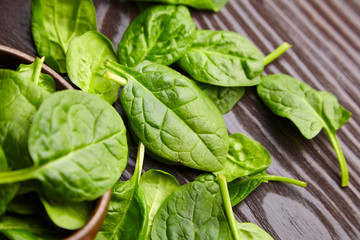 Spinach fresh green leaves in a wooden background