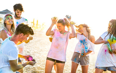 Happy friends having fun at beach party in holi colors summer festival - Young people millennial...