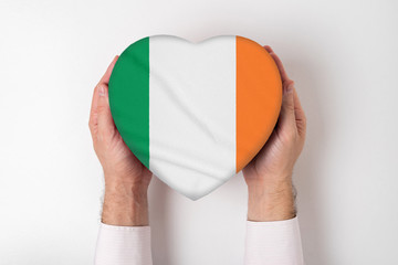 Flag of Ireland on a heart shaped box in a male hands. White background